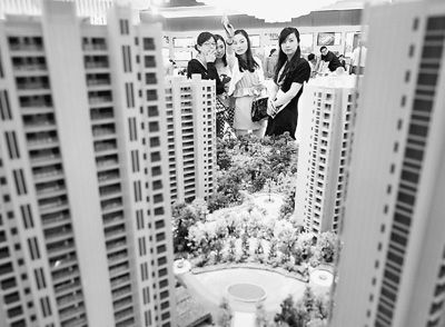 圖為近日，浙江杭州一家房產公司的兩位銷售人員一起向購房者介紹樓盤。新華社記者 王定昶攝