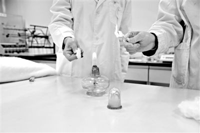 實驗人員操作的燃燒檢測法中，真蠶絲離開火焰就熄滅(左)。