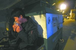 快遞哥抽空吃兩口東西。記者 李剛 攝
