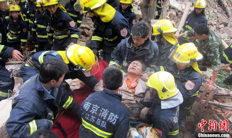 圖為南京消防隊員從廢墟中將傷者抬出。中新社發(fā) 梅亮 攝
