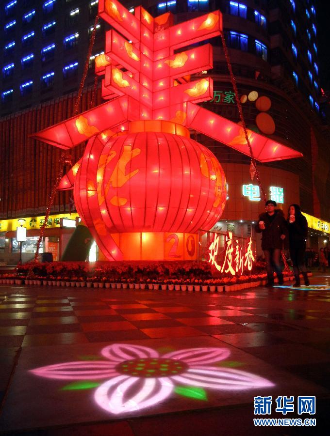 　1月30日晚，市民從蘇州市石路銀河廣場上大型“春”字彩燈景觀旁經過。
