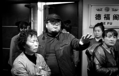 昨日，在河北香河天下第一城，相關(guān)負責(zé)人（左二）走出會議室與參加演出的老人們溝通。
