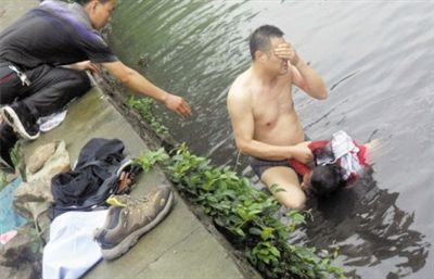 網(wǎng)友貼出民警張光聰一出河水就睜不開眼，用手抹去臉上臟水的照片。