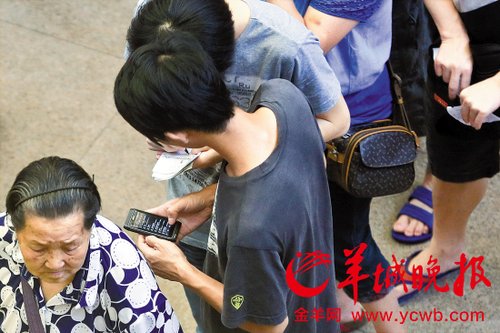 排隊(duì)的“黃?！备魇謭?zhí)一疊白紙，上面寫好了要掛號(hào)的人的信息，包括姓名、電話、要掛的科室等。穿黑白花紋衣服的老婆婆正在排隊(duì)掛號(hào)