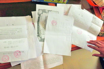 60歲的市民仇先生為了辦理公證所需的這些證明材料,半個月時間里跑了30多趟腿。記者　李萌博　攝
