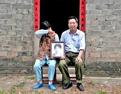 江蘇鎮(zhèn)江，老劉夫婦捧著獨(dú)生子的遺像在老家前留影南方都市報(bào)供圖L
