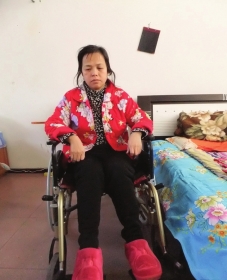 陳慶霞坐在輪椅上。她現(xiàn)在下身癱瘓，疾病纏身，生活不能自理。