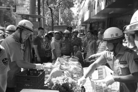 7月11日，瀏陽(yáng)市北正中路，執(zhí)法人員暫扣張海的水果。這是瀏陽(yáng)市城管局拍攝的執(zhí)法現(xiàn)場(chǎng)圖。
