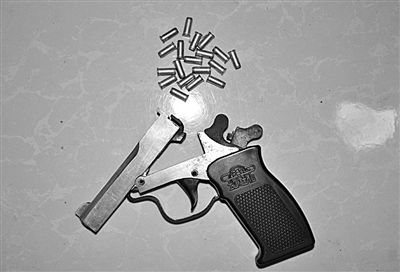 警方從搶劫嫌疑人處起獲的贓款和發(fā)令槍、子彈。警方供圖