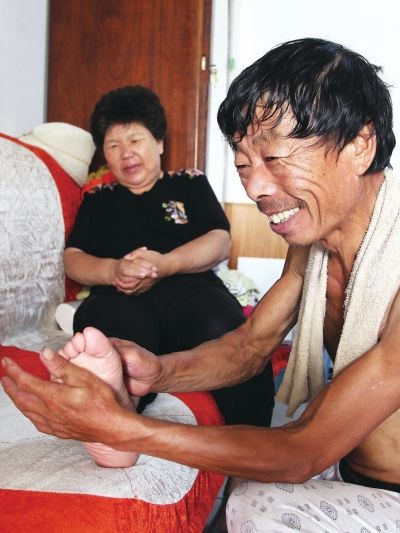 慈成富為老伴按摩。