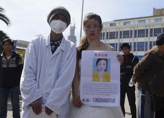 昆明火車站廣場上，24歲的黃習菊身穿潔白的婚紗，帶著身患白血病的弟弟征婚。