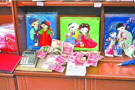 　　2012年6月21日，在朝鮮羅先特別市的一家商店里，柜臺上散落著一些人民幣。在朝鮮，人民幣比本國