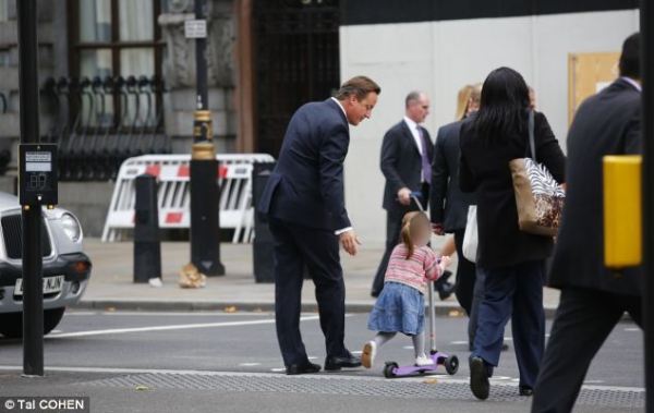 英國(guó)首相卡梅倫步行送女兒上幼兒園。