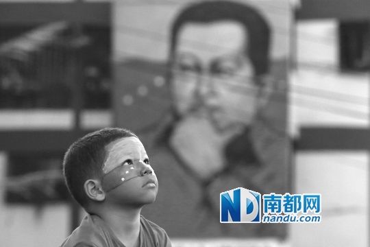 3月5日，一名委內(nèi)瑞拉兒童仰望天空，他身后是查韋斯的陵墓。