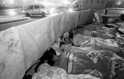 在寒冷的冬夜，為了能省點錢，方便接活，民工們仍睡在橋下。