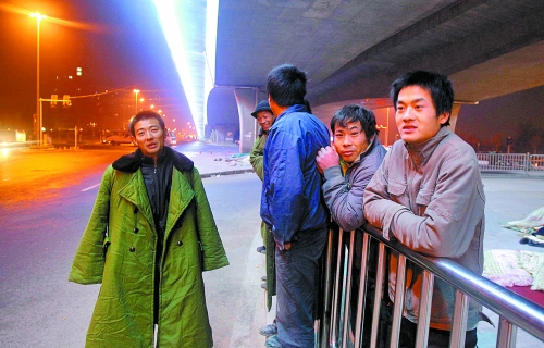 冬夜里，農(nóng)民工在橋下等著干活兒。
