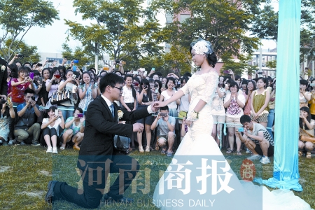 在學(xué)校操場(chǎng)的草坪上，兩名畢業(yè)生舉行婚禮，有同學(xué)感動(dòng)地抹起眼淚