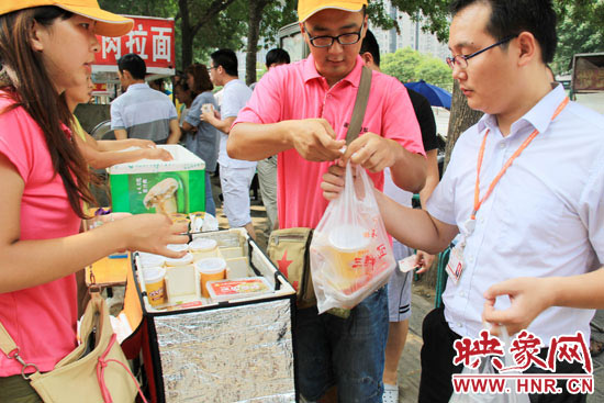 圖為徐貴雨和一名勤工助學(xué)的學(xué)生在街頭義賣快餐。