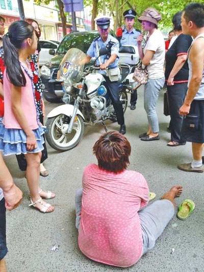 在鄭州優(yōu)勝南路東三街交叉口向東100米處，一名短發(fā)中年女子平躺在路南快車道上，身旁還有一只掉落的拖鞋