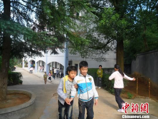 4年來(lái)，13歲的余興泉（左一）每天都攙扶著腿腳不便的同學(xué)左臣進(jìn)出教室、食堂和廁所。 李俊杰 攝