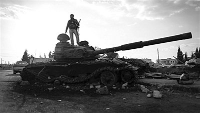 9月8日，敘利亞Zabadani，一名敘利亞反對派武裝人員站在廢棄的政府軍坦克上。