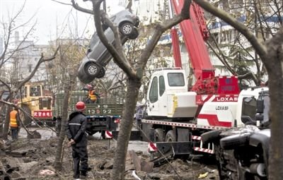 輸油管道爆炸后，搶修人員將被炸毀的車輛運出現(xiàn)場。