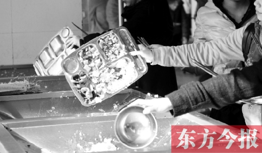 11月27日，河南中醫(yī)學(xué)院餐廳，一名同學(xué)將餐盤內(nèi)沒吃完的食物倒入餐具回收車內(nèi)