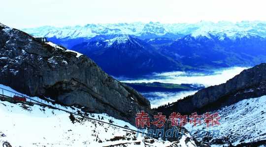  齒軌火車(chē)在皮拉圖斯山上穿行，如同紅色的龍?jiān)谏街杏芜? complete=