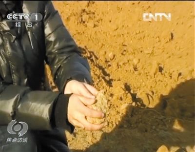 麻剛沙系麻剛石粉碎而成。記者找到一塊麻剛石，一捏就碎成粉末，硬度非常差。央視截圖