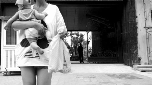 抱著孩子出售人奶的女子。