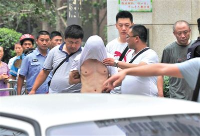 昨日，成都警方抓捕時(shí)與毒犯發(fā)生槍?xiě)?zhàn)。一名男犯罪嫌疑人被警方押出。