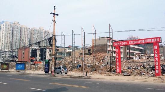 015年5月31日，在社區(qū)干部的帶頭拆遷下，親賢社區(qū)的“城中村改造”拉開帷幕。由于前期“清產(chǎn)核資”及補(bǔ)償標(biāo)準(zhǔn)等因素，拆遷改造工作推進(jìn)并不順利。圖為位于體育西路東側(cè)集體所有的商鋪率先被拆遷完畢，用于遮擋的圍擋正在施工中。（拍攝：2015年9月16日）