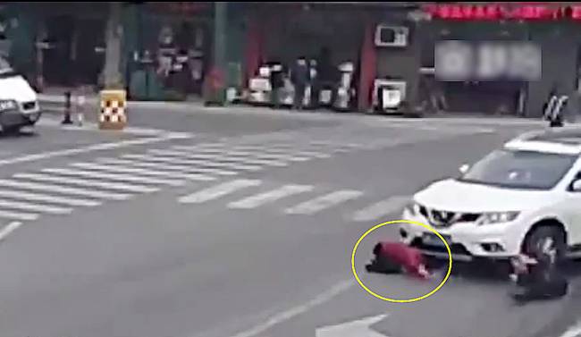 圖為小姑娘被卷進(jìn)車輪下瞬間。