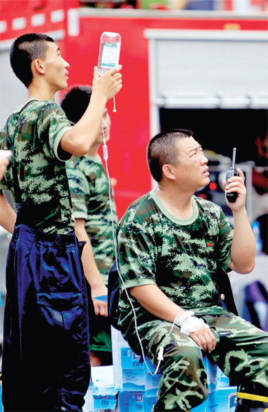 火場外，被消防戰(zhàn)士稱為“李大隊”的救援人員掛著吊瓶現(xiàn)場指揮