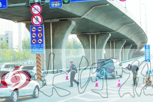 交警在東風(fēng)路從北向南上橋口處擺上反光錐，間歇放行
