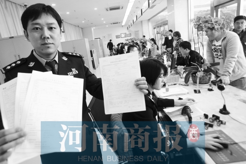 　民警左手拿的是新申請(qǐng)表，右手拿的是三份老申請(qǐng)表 王春勝/攝