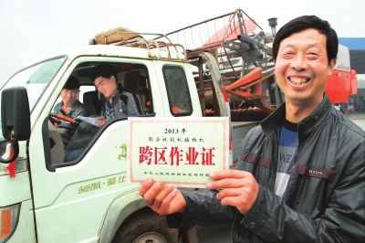 　5月6日，縣嘉應(yīng)觀鄉(xiāng)東營村農(nóng)機手荊占通在展示他的跨區(qū)作業(yè)證。當(dāng)日，該縣60多臺履帶式收割機奔赴四川