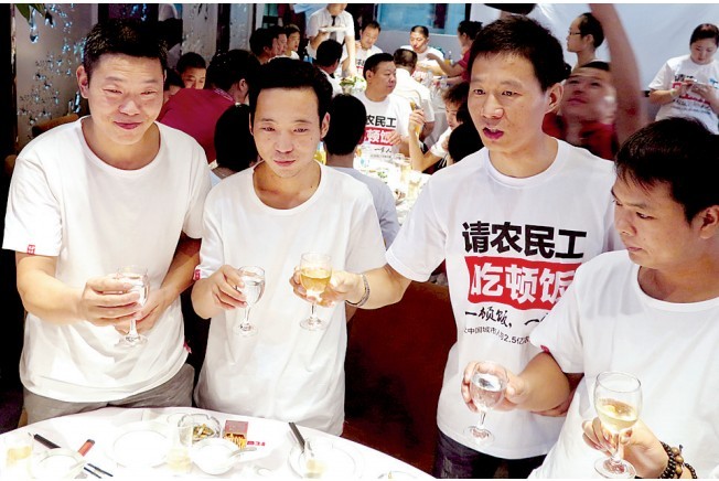 活動發(fā)起人張楠（右二）給農(nóng)民工敬酒。