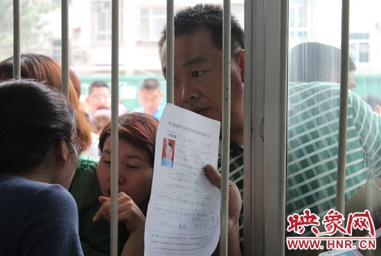 不少家長擠在報(bào)名窗口前咨詢報(bào)名事宜。