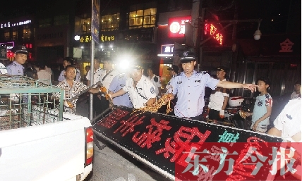 7月8日晚，鄭州市商城路一家占道經(jīng)營(yíng)的攤販招牌被執(zhí)法隊(duì)員“登記保存”