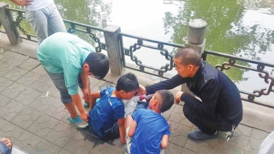 男孩被救出后，圍觀群眾幫他控水換衣服。