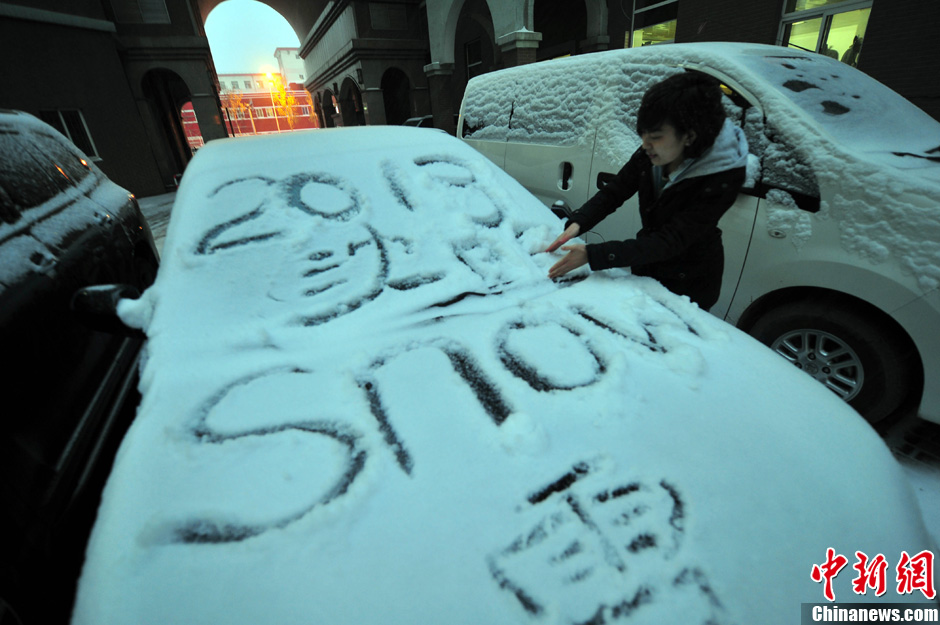 11月18日，行人在車輛的積雪上涂鴉。