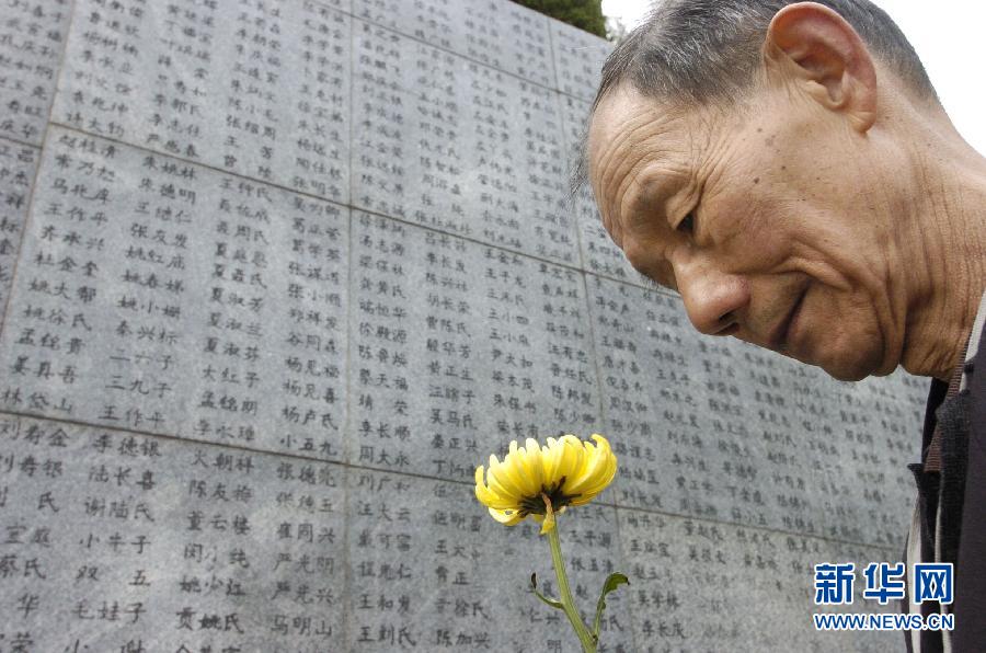 2006年4月5日，74歲的南京大屠殺幸存者佘子清手捧鮮花，祭奠被日軍殺害的母親。