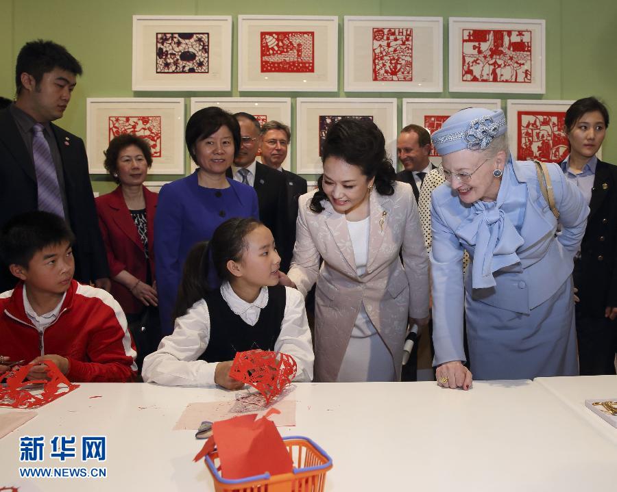 這是彭麗媛和瑪格麗特二世與根據(jù)安徒生童話中人物和情節(jié)制作剪紙的孩子交談。