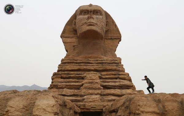 石家莊郊外，一名男子與山寨版獅身人面像合影留念。