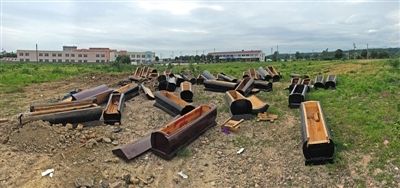 40多副棺木被砸壞后，扔在荒地上。