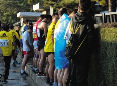 2013年10月20日，北京馬拉松比賽，由于廁位有限，一些選手在綠化帶“就地解決”。圖/IC