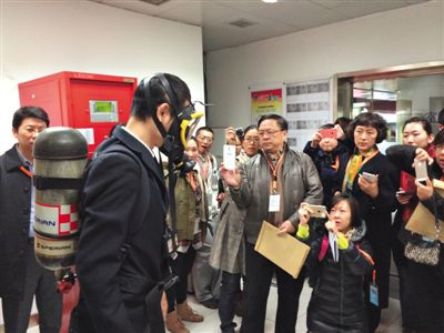 昨天，地鐵4號線北京南站站，地鐵工作人員為人大代表演示應(yīng)急氧氣瓶佩戴方式。新京報記者