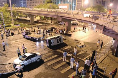 路虎沖下國貿(mào)橋砸中一輛起亞轎車，橋上厚達(dá)幾十厘米的水泥護(hù)欄被撞斷，碎石四處散落，數(shù)十群眾在現(xiàn)場圍觀。