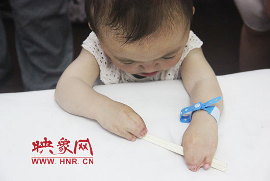 孩子握著筷子發(fā)呆。